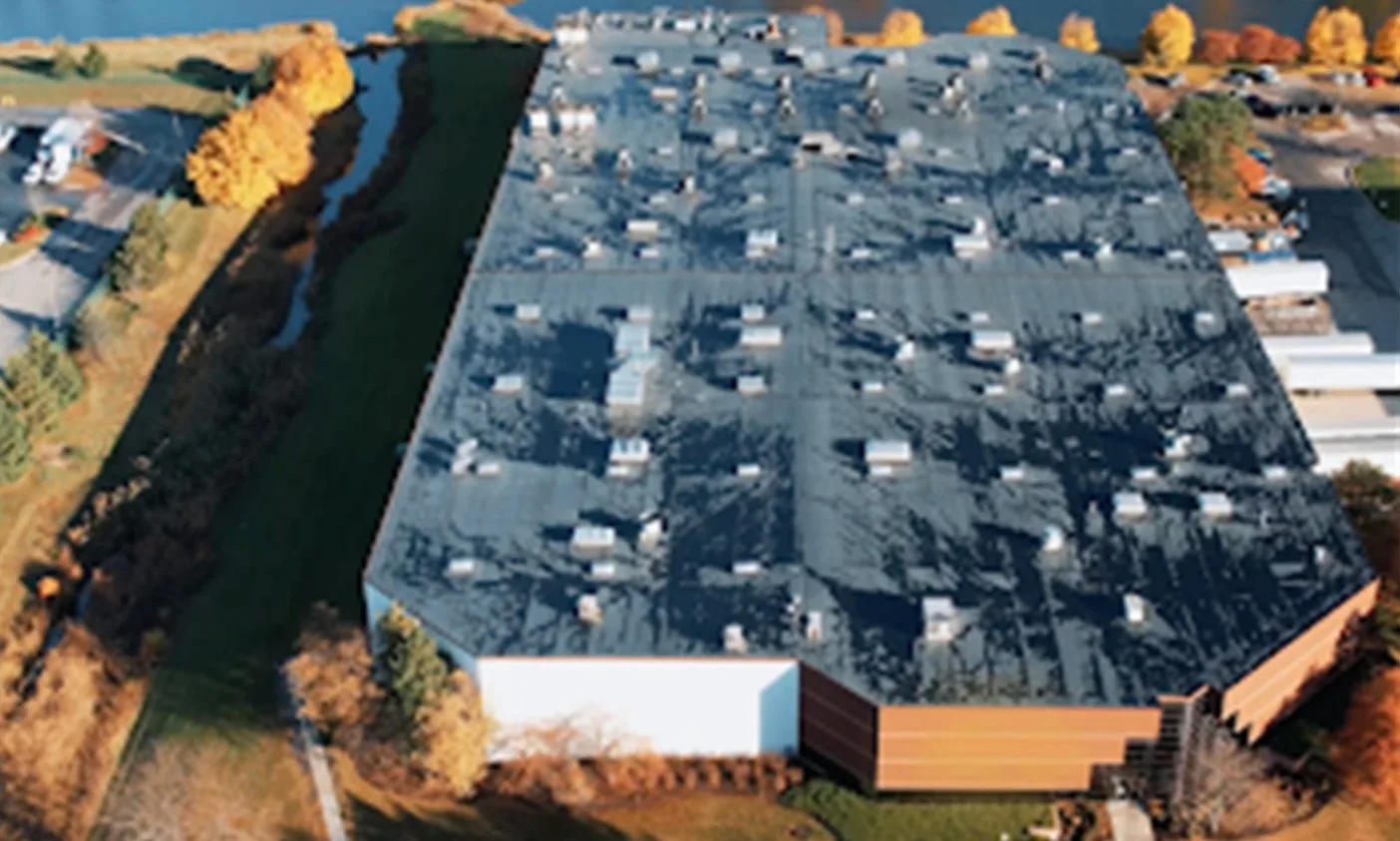 Aerial view of the Linamar Light Metals plant in Pleasant Prairie beside a waterway in autumn.